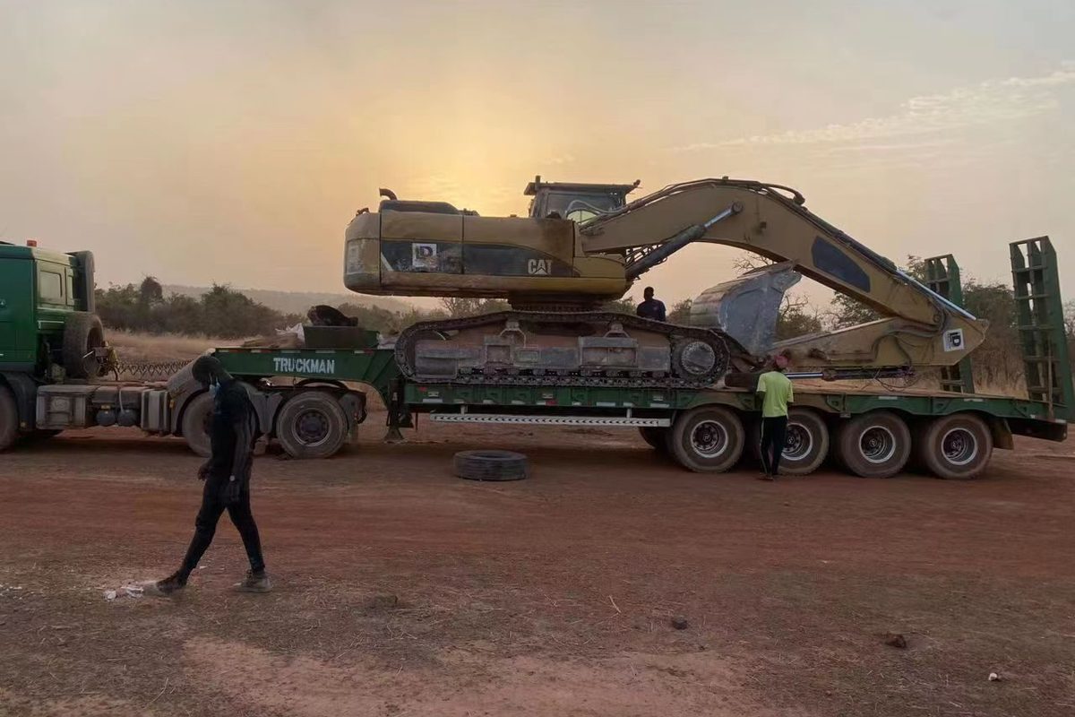 Low bed semi trailer transporting excavator